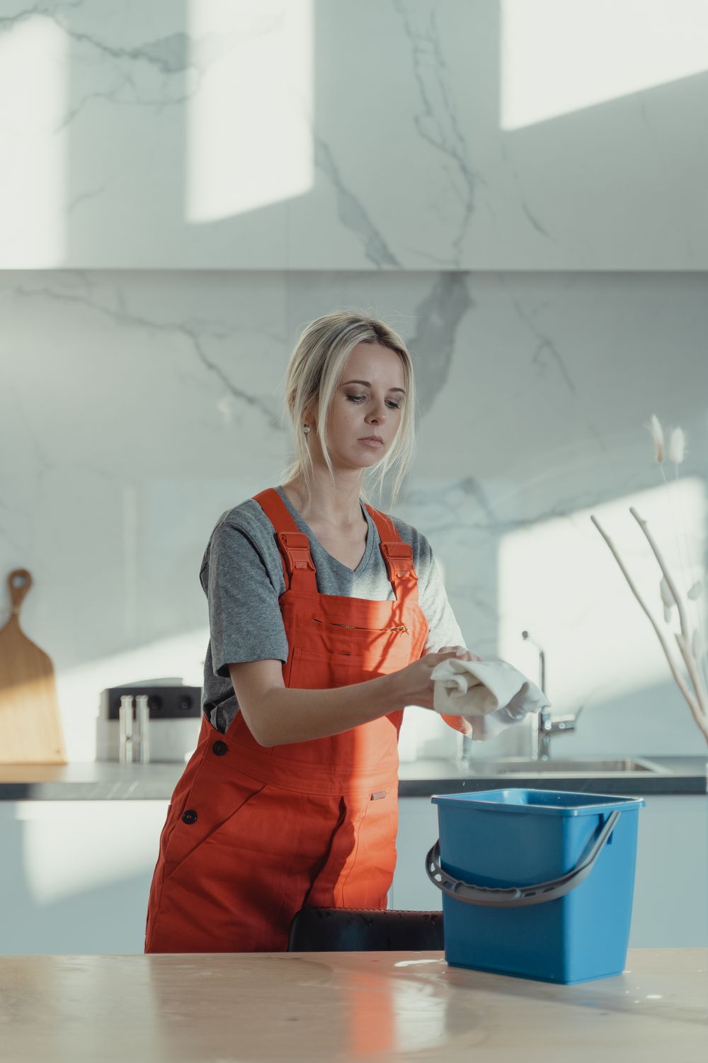 A cleaner wiping a bright kitchen counter